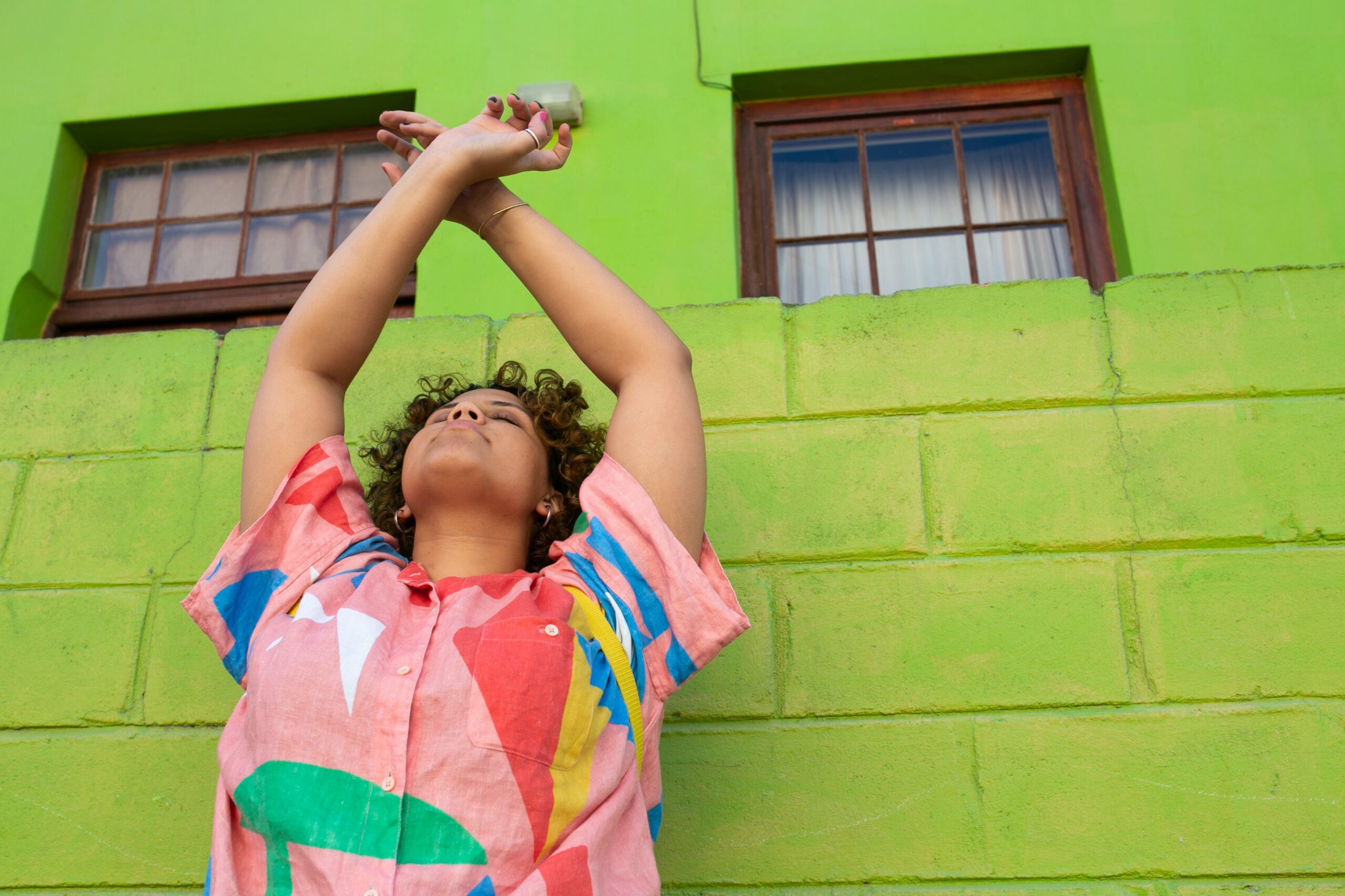 A person stretching near a green wall