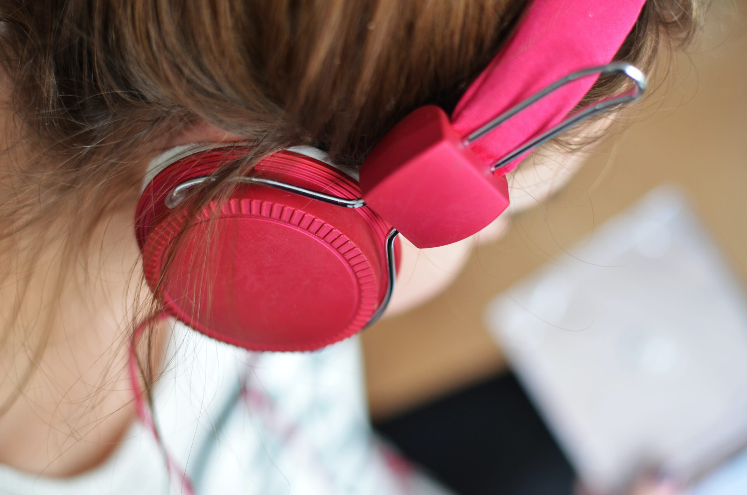 up close shot of person wearing pink headphones