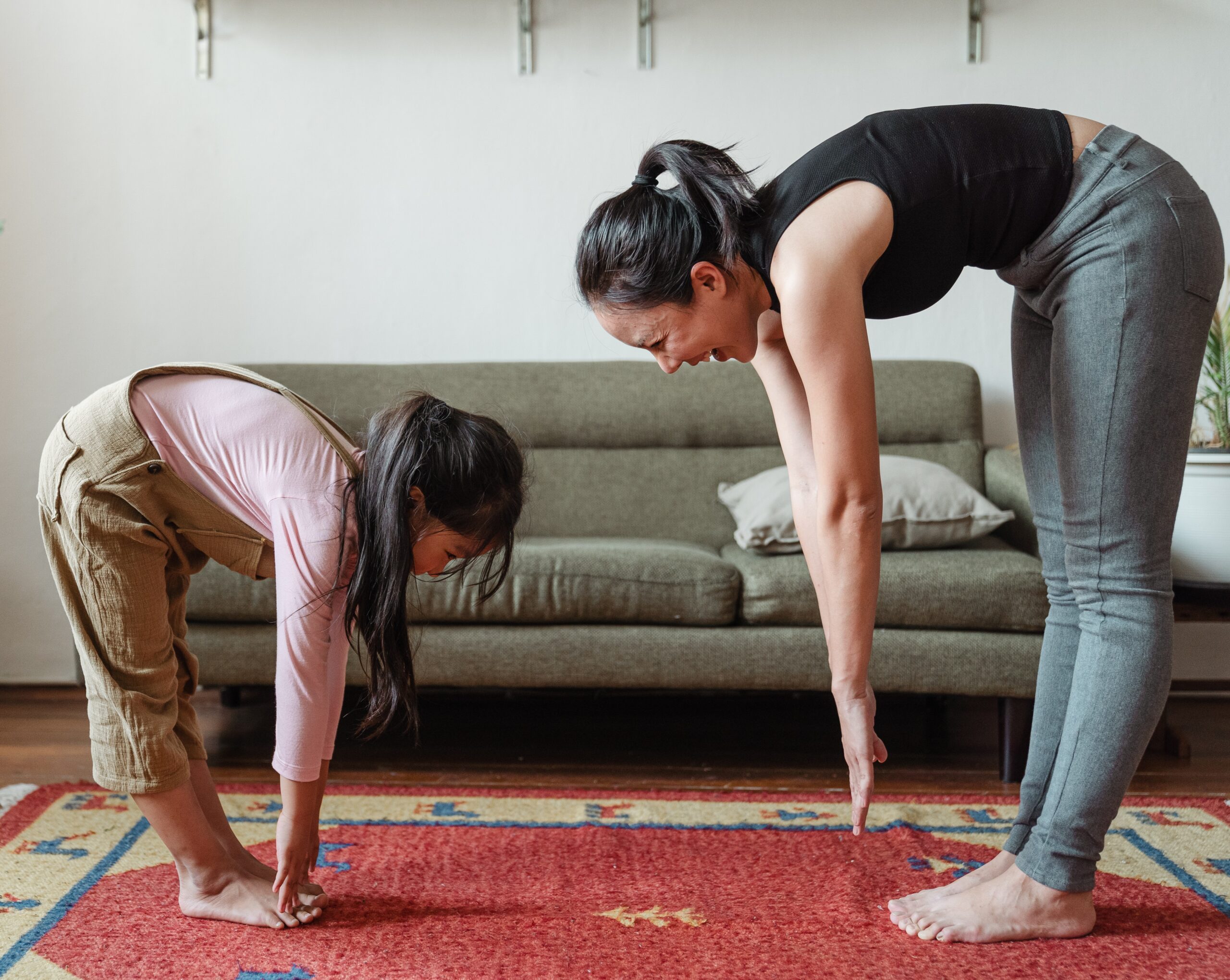 parent and child in exercise clothes reaching to touch their toes